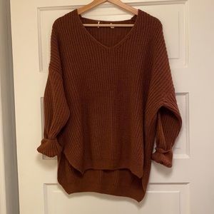 This brown/red sweater is a size small/medium. It is by the brand dreamers.